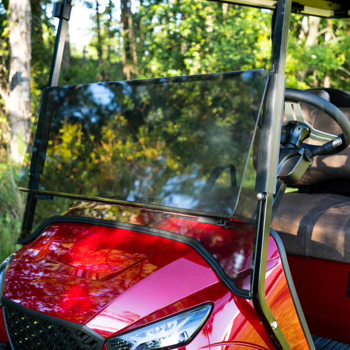 Folding Tinted 1/4" Windshield for Storm Body Kits with 3/4 Struts – installed on red golf cart, close-up